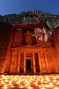 Petra by Night. On certain nights candles are lit at Petra's iconic Treasury. I was lucky enough to witness this with a rising full moon. The moon nicely lights the mountain top and upper part of the Treasury. A combination of candlelight and reddish sandstone creates the beautiful orange-red colors. This is a 4 min(!) exposure of the event which causes small star trails to appear in the night sky. : Jordan